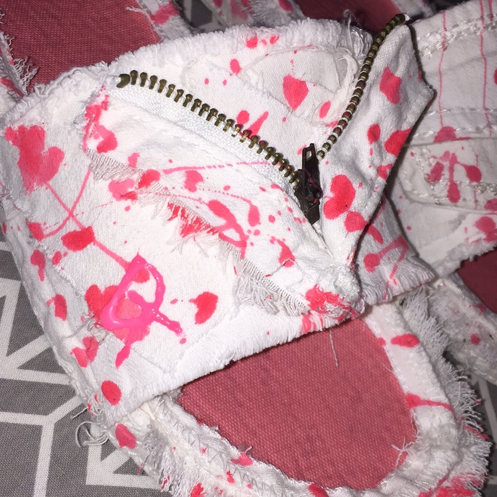 White denim slides with pink splatter.
